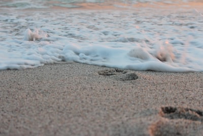 白天棕色沙滩上的白色海浪
